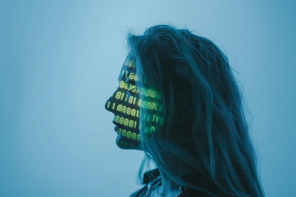 Silhouette of a woman with binary code projected on her face in a digital concept setting.